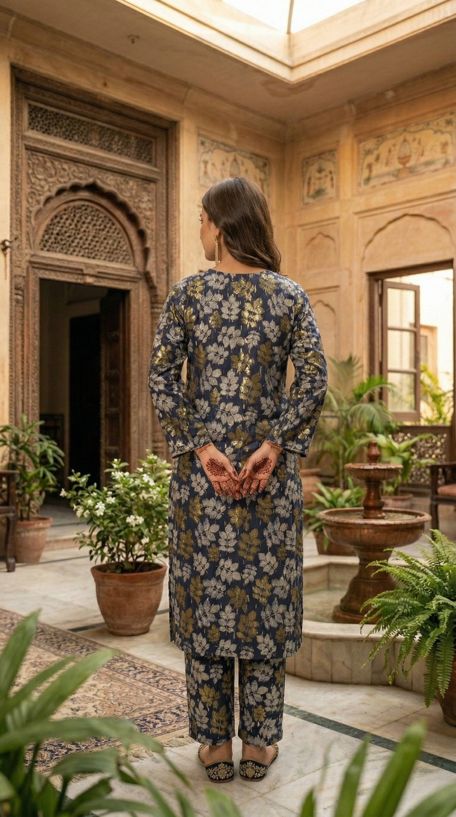 Woman wearing stitched navy blue floral printed 2 piece eastern suit with matching trousers in a traditional courtyard setting by Sijday.