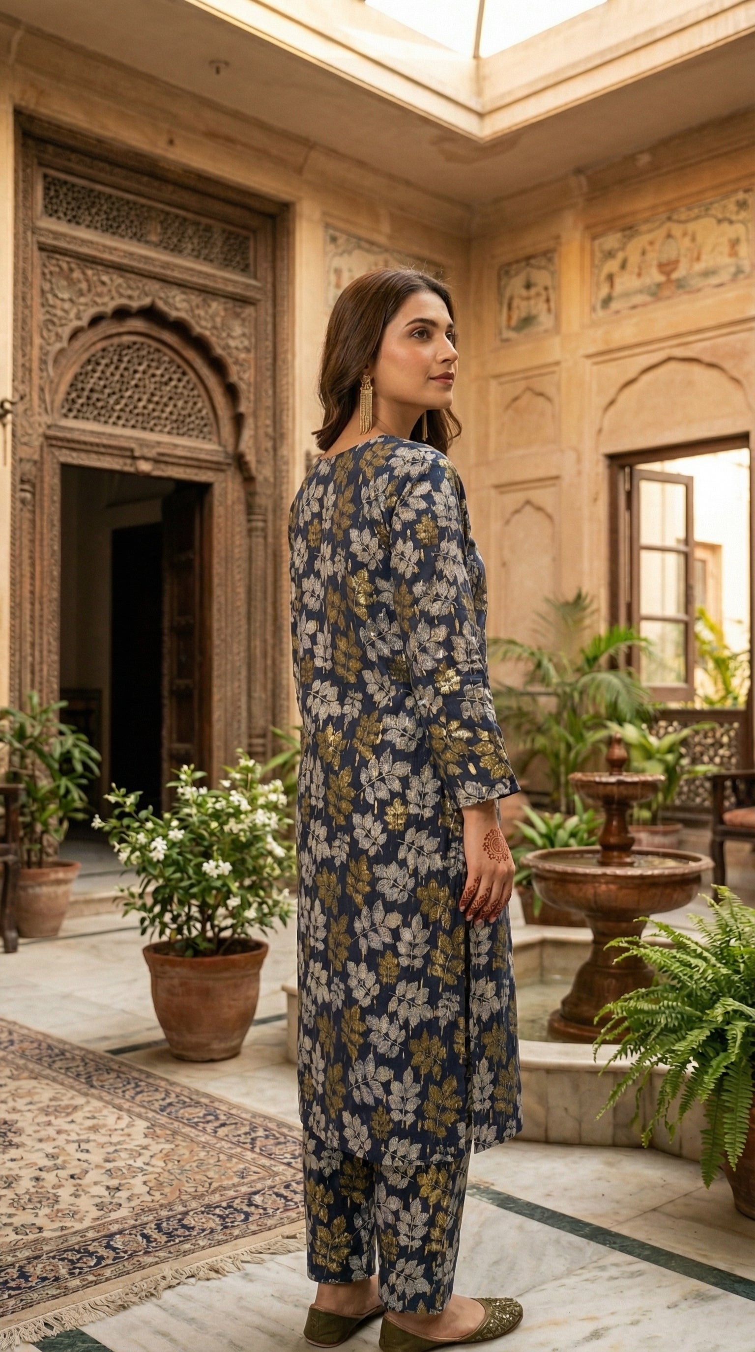 Woman wearing stitched navy blue floral printed 2 piece eastern suit with matching trousers in a traditional courtyard setting by Sijday.